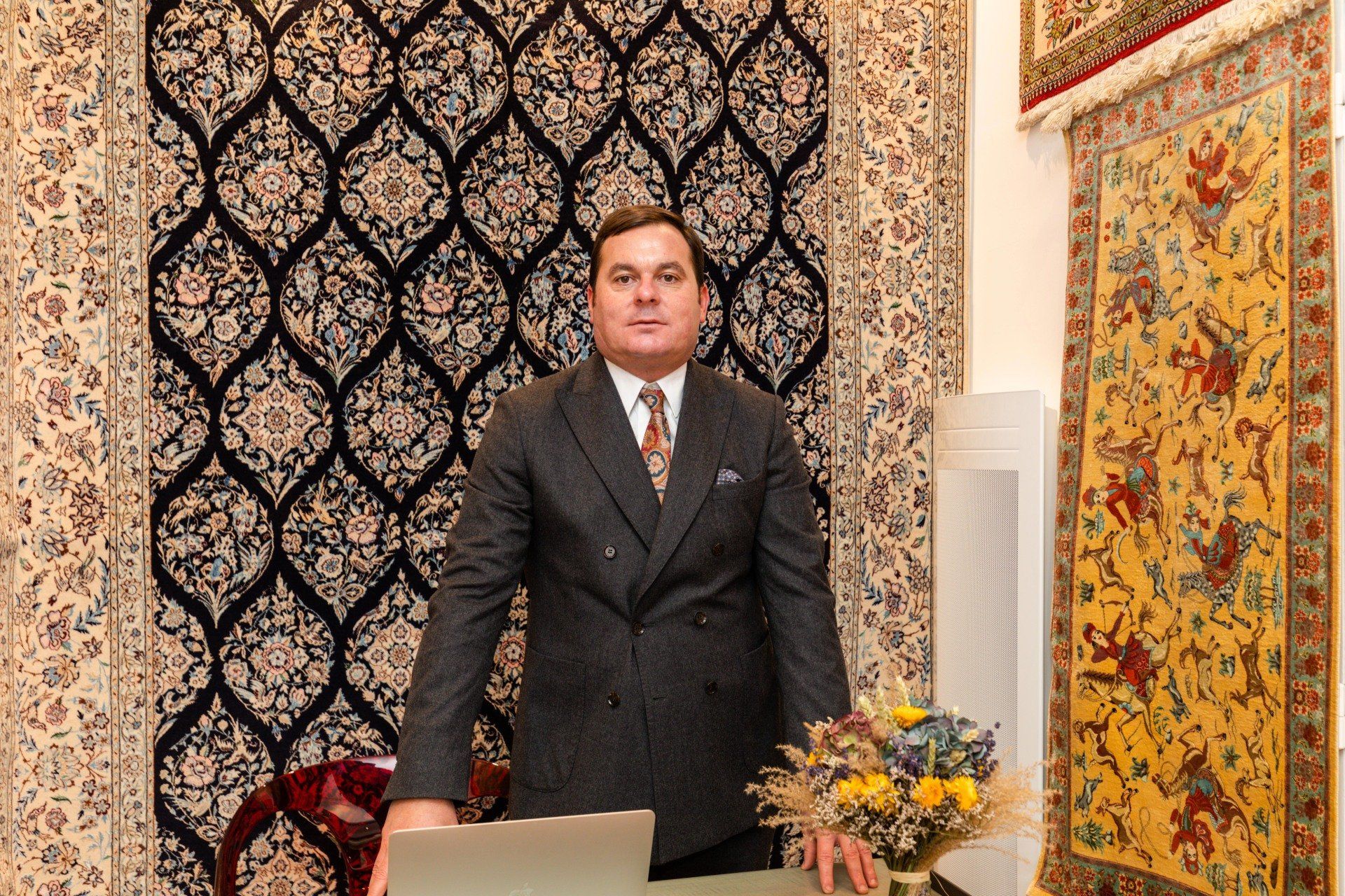 Professionnel en costard derrière son comptoir pour une estimation de tapis