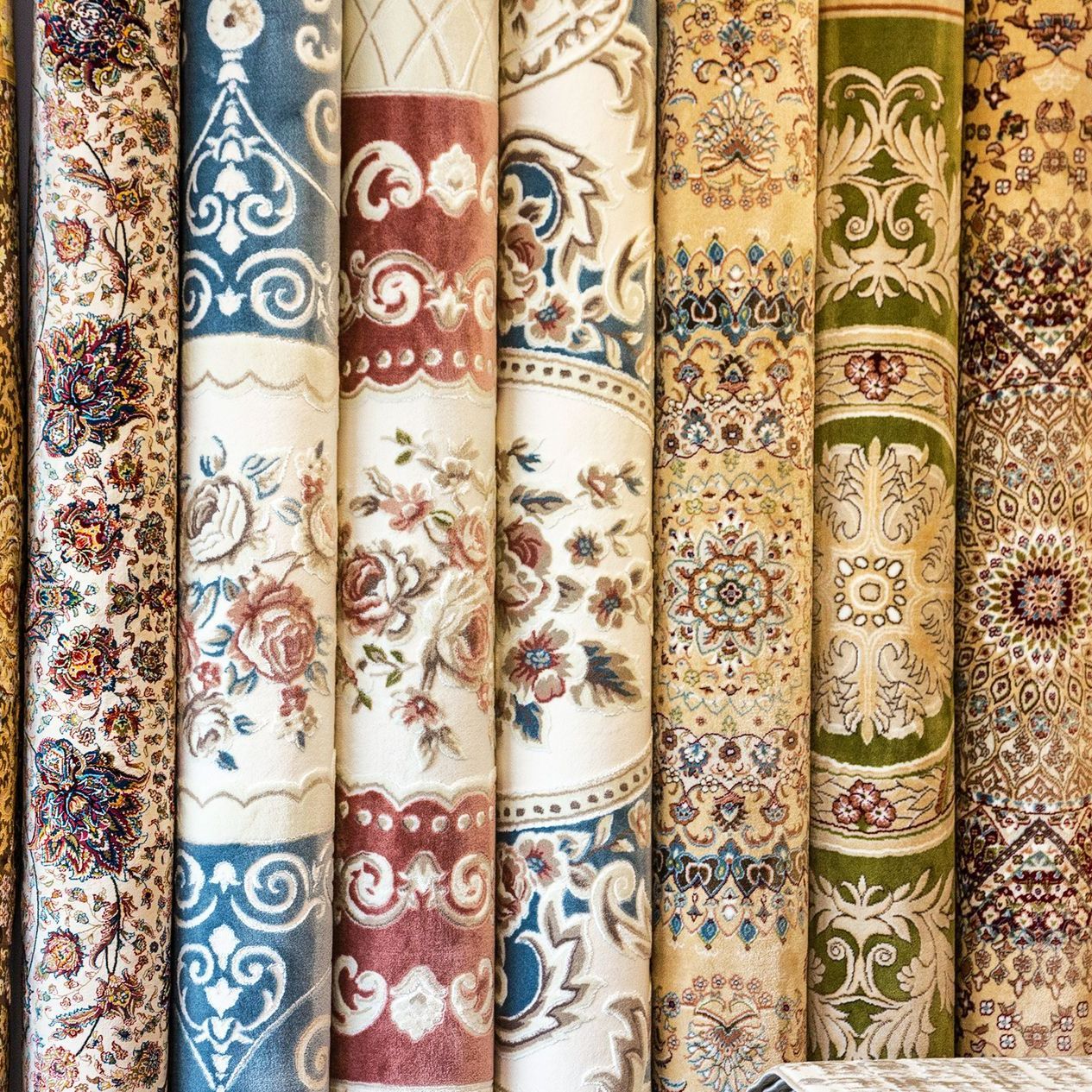 Différentes collections de tapis enroulés et beiges