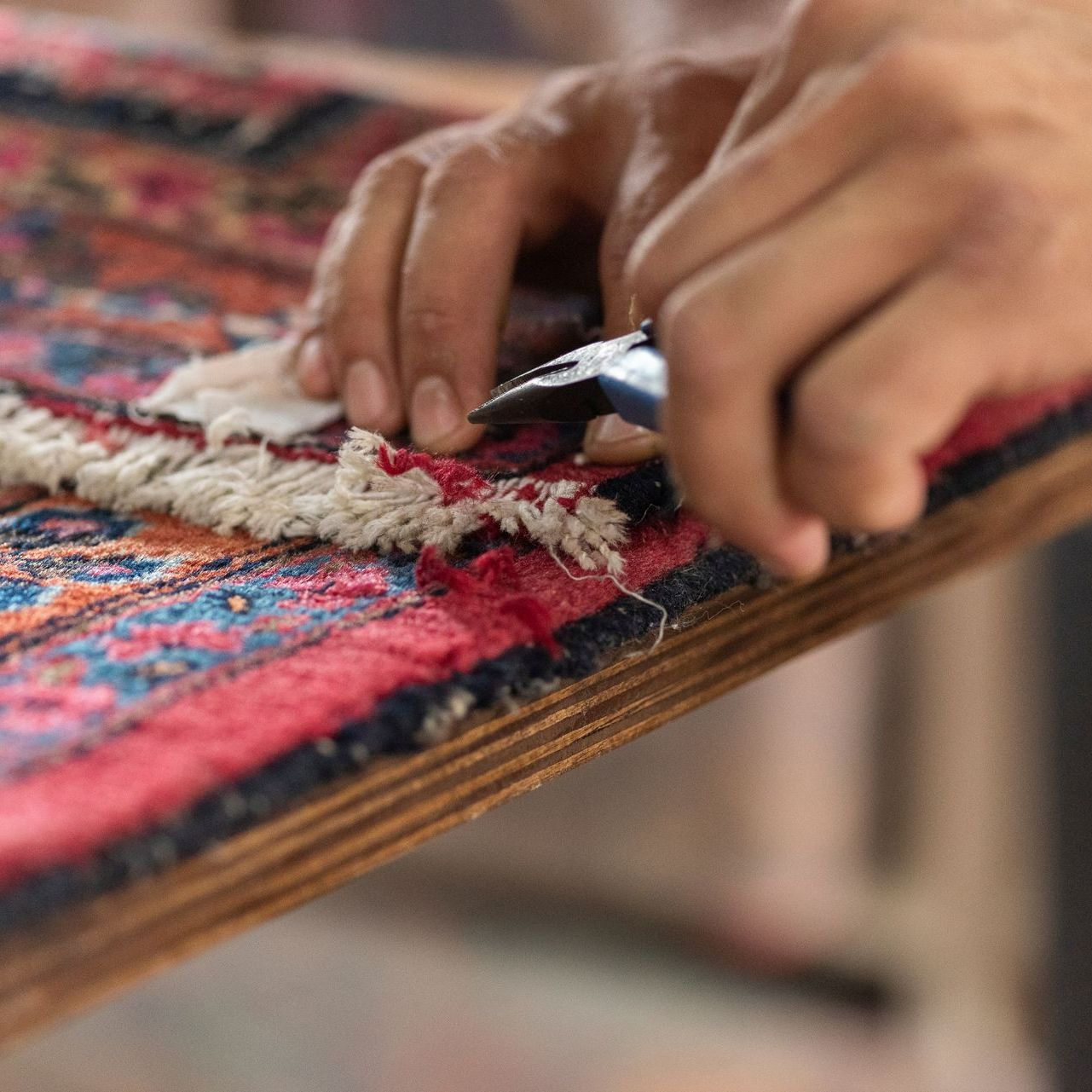 Réparation de franges d'un tapis rouge