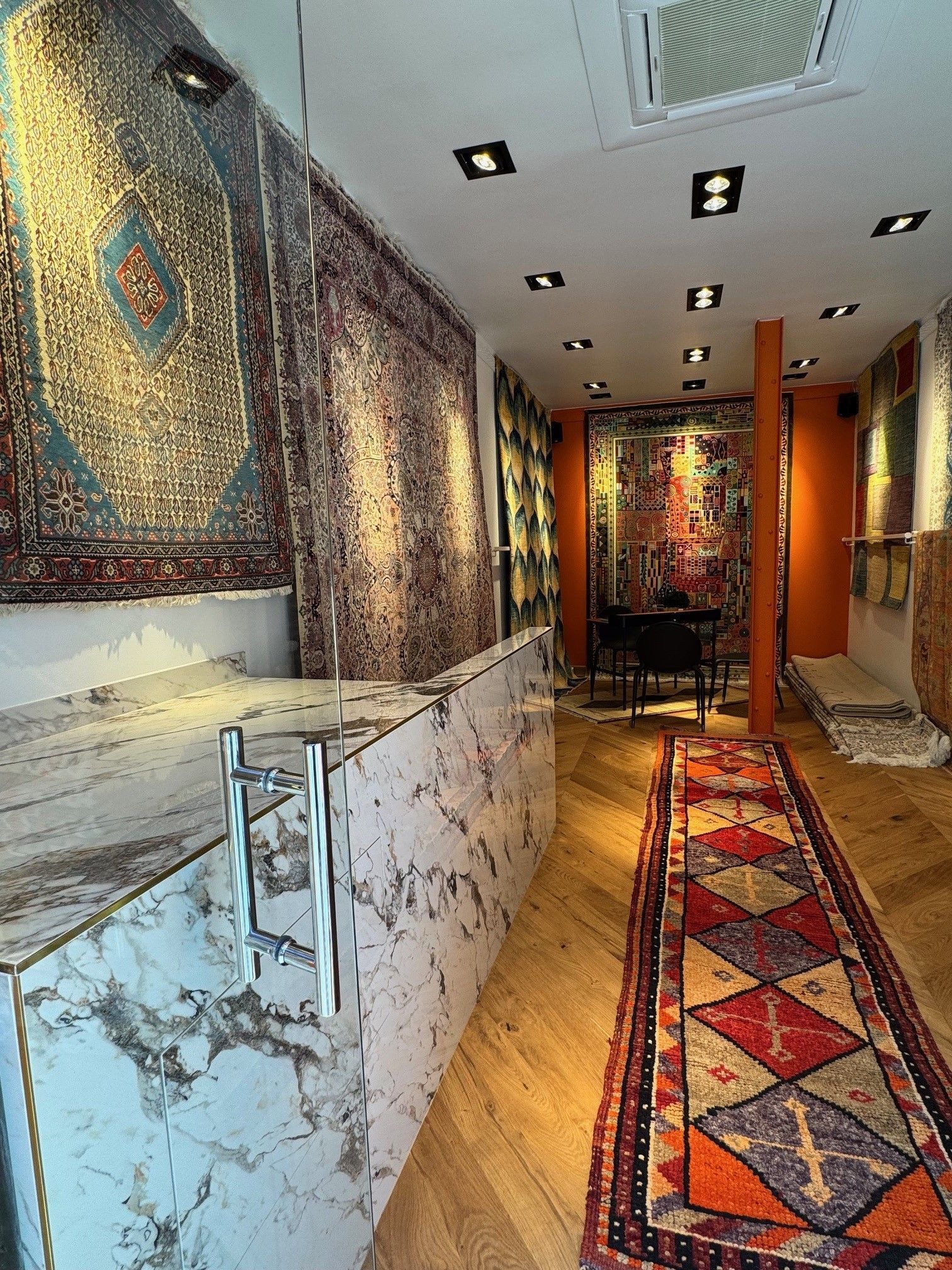 Porte vitrée ouverte donnant sur un magasin de tapis