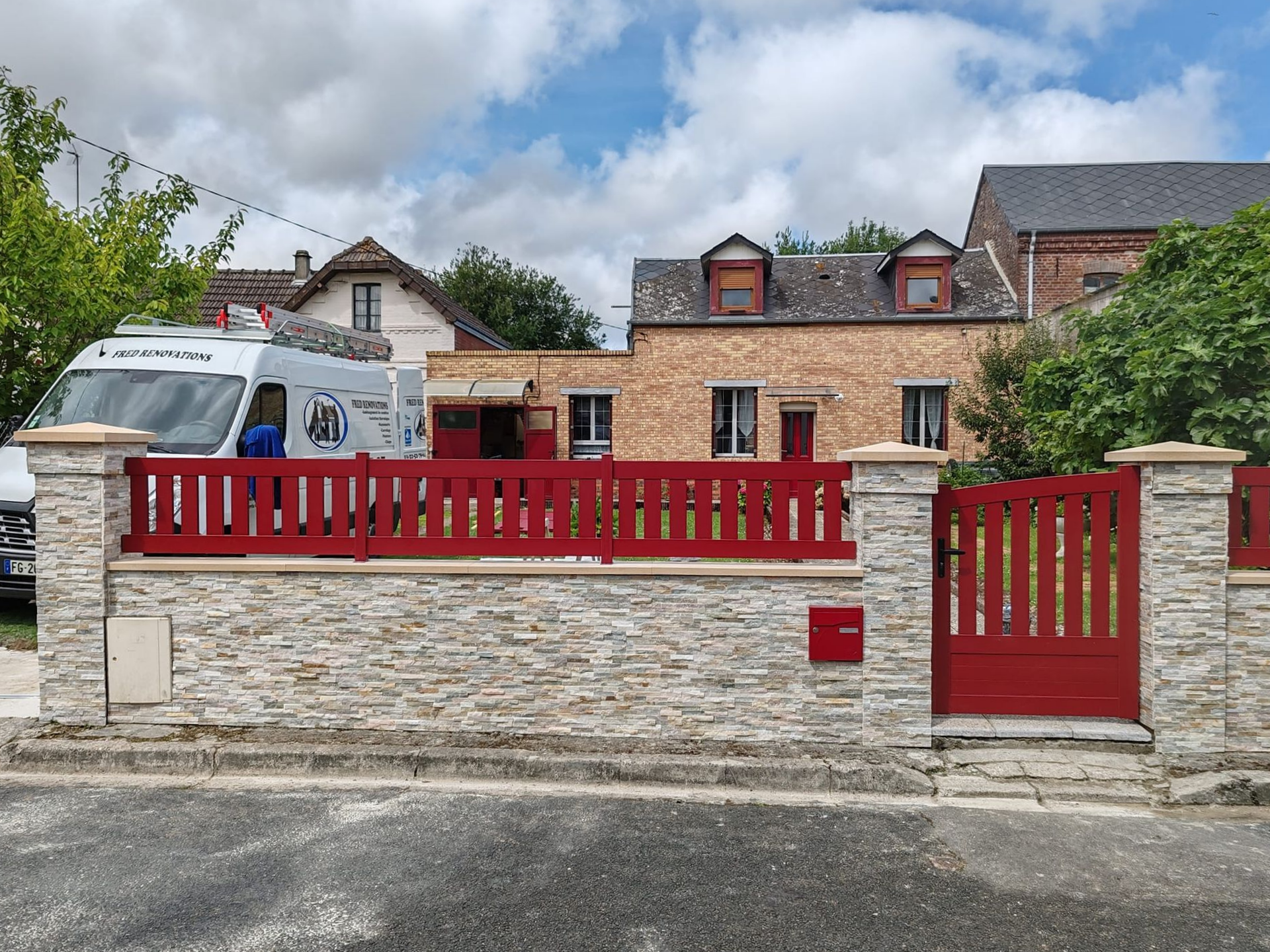 Pièce moderne et vide, avec des murs gris et blancs, un parquet blanc et un mur d'accent en briques.
