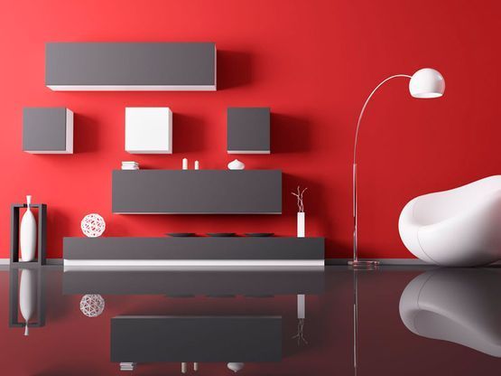 Una sala de estar con paredes rojas y muebles negros.