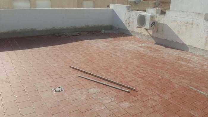 Un patio de ladrillo con un par de palos encima.