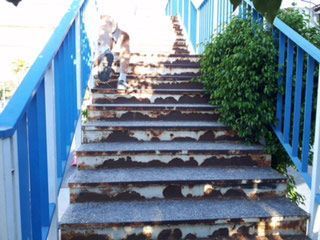 Un conjunto de escaleras que conducen a un puente con una barandilla azul.