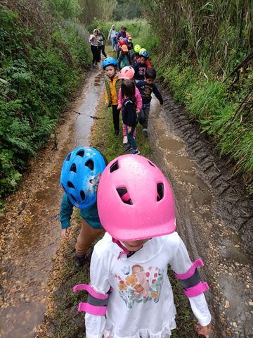 Um grupo de crianças está caminhando por um caminho lamacento.