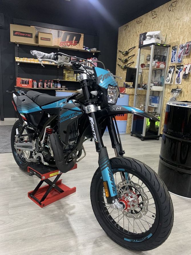 Una motocicleta está estacionada en un elevador en un garaje.