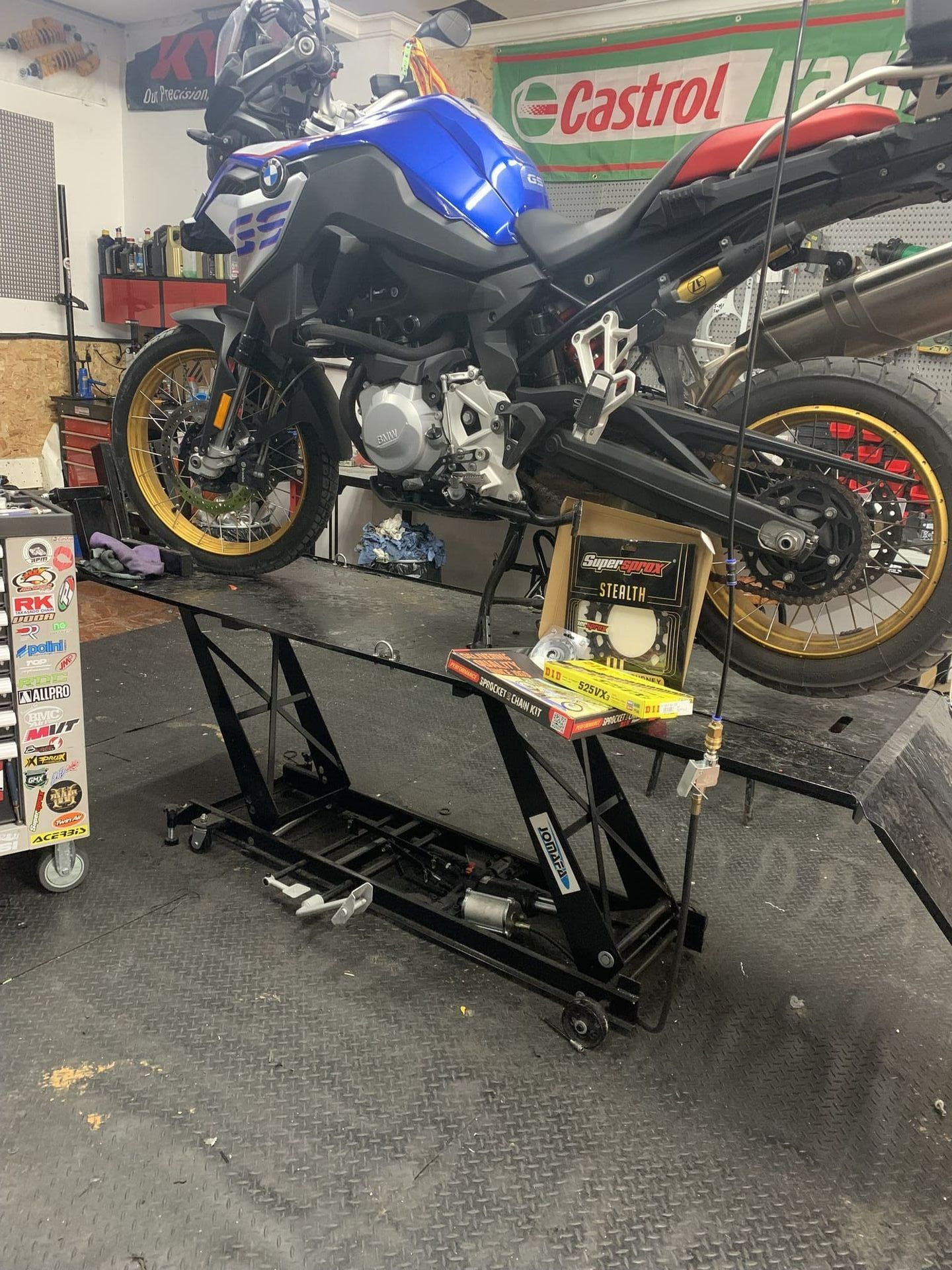 Una motocicleta está parada encima de un elevador en un garaje.