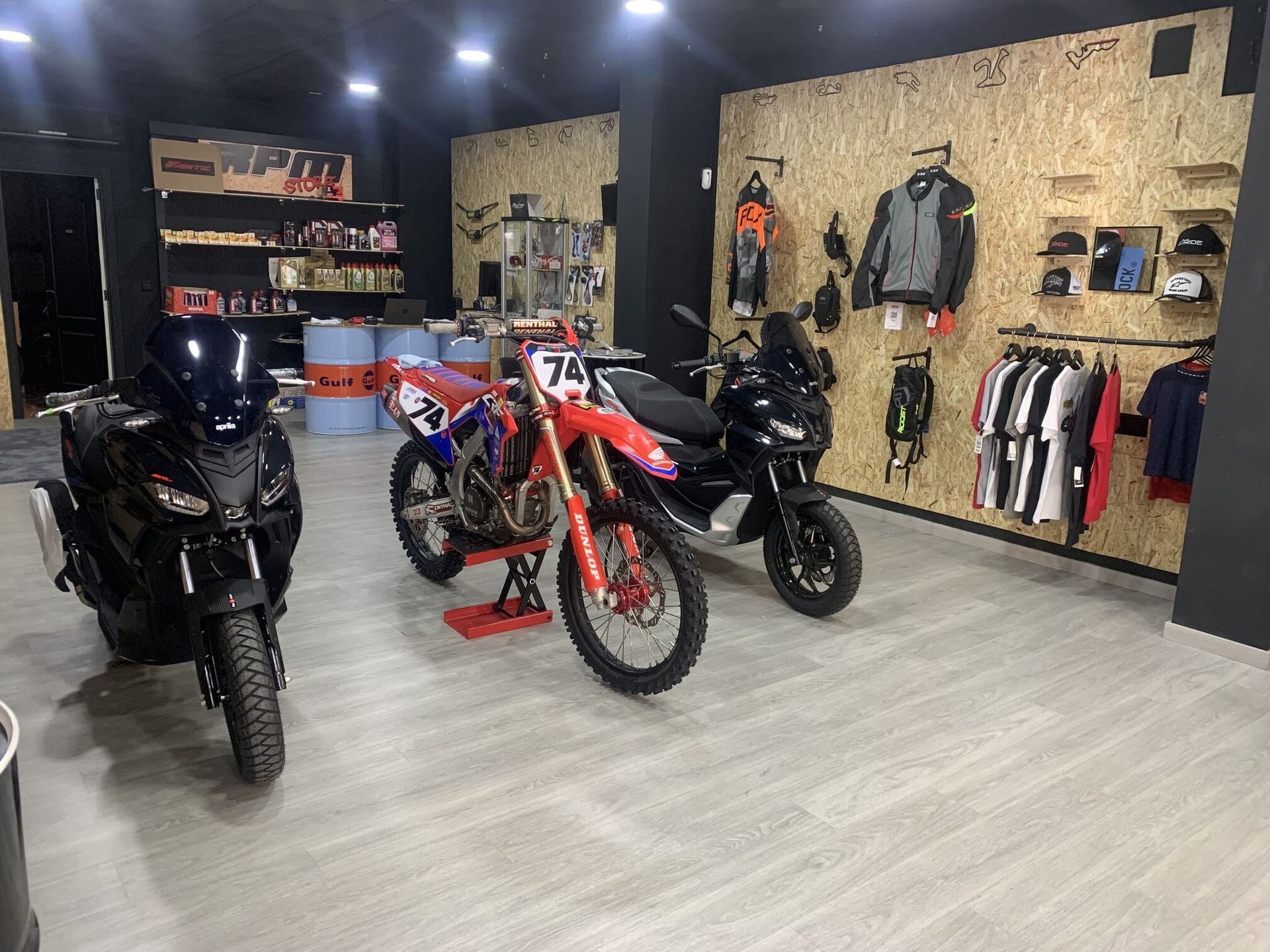 Tres motocicletas están estacionadas en una habitación en una tienda de motocicletas.