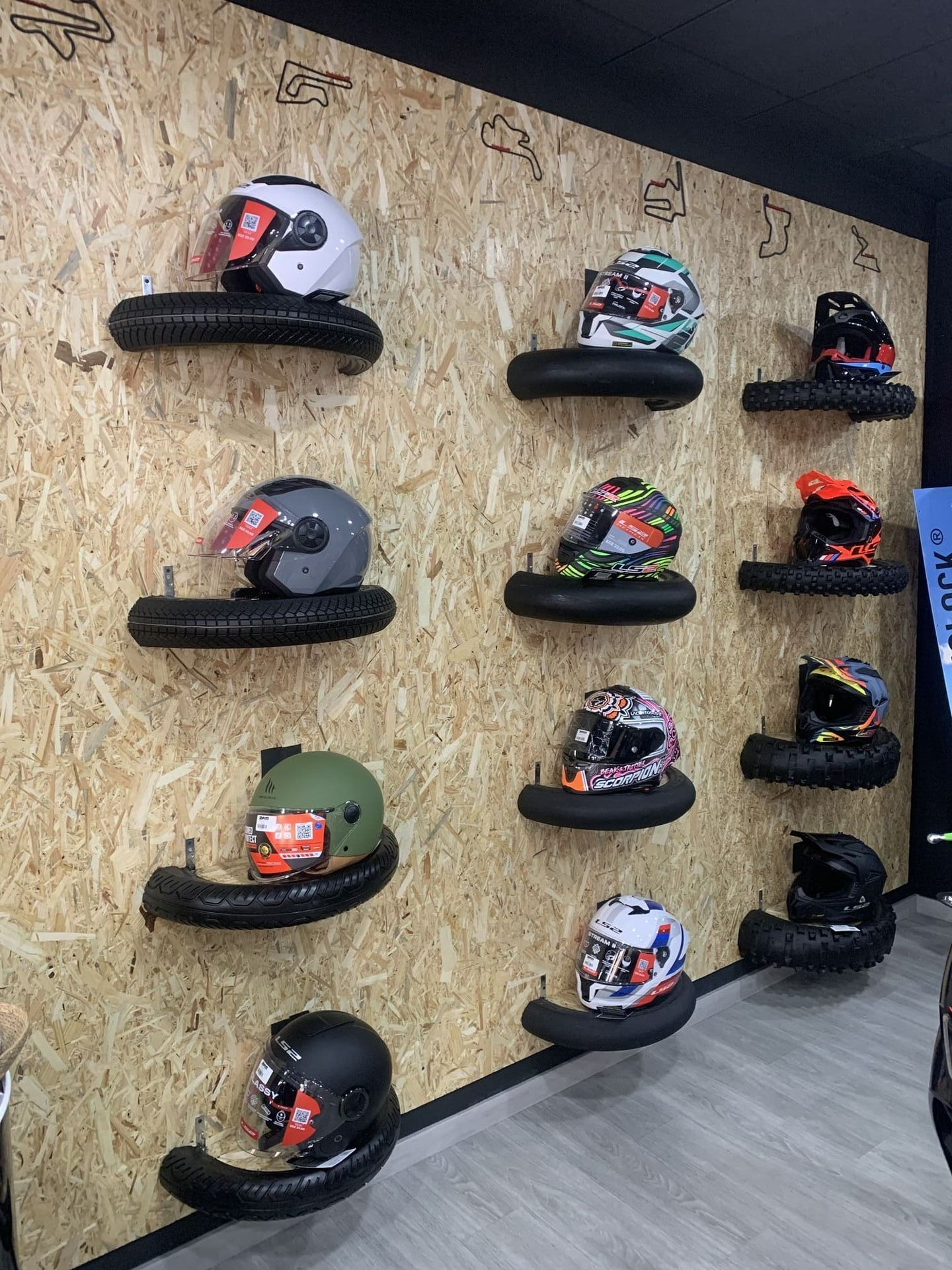 Una pared con muchos cascos colgados.