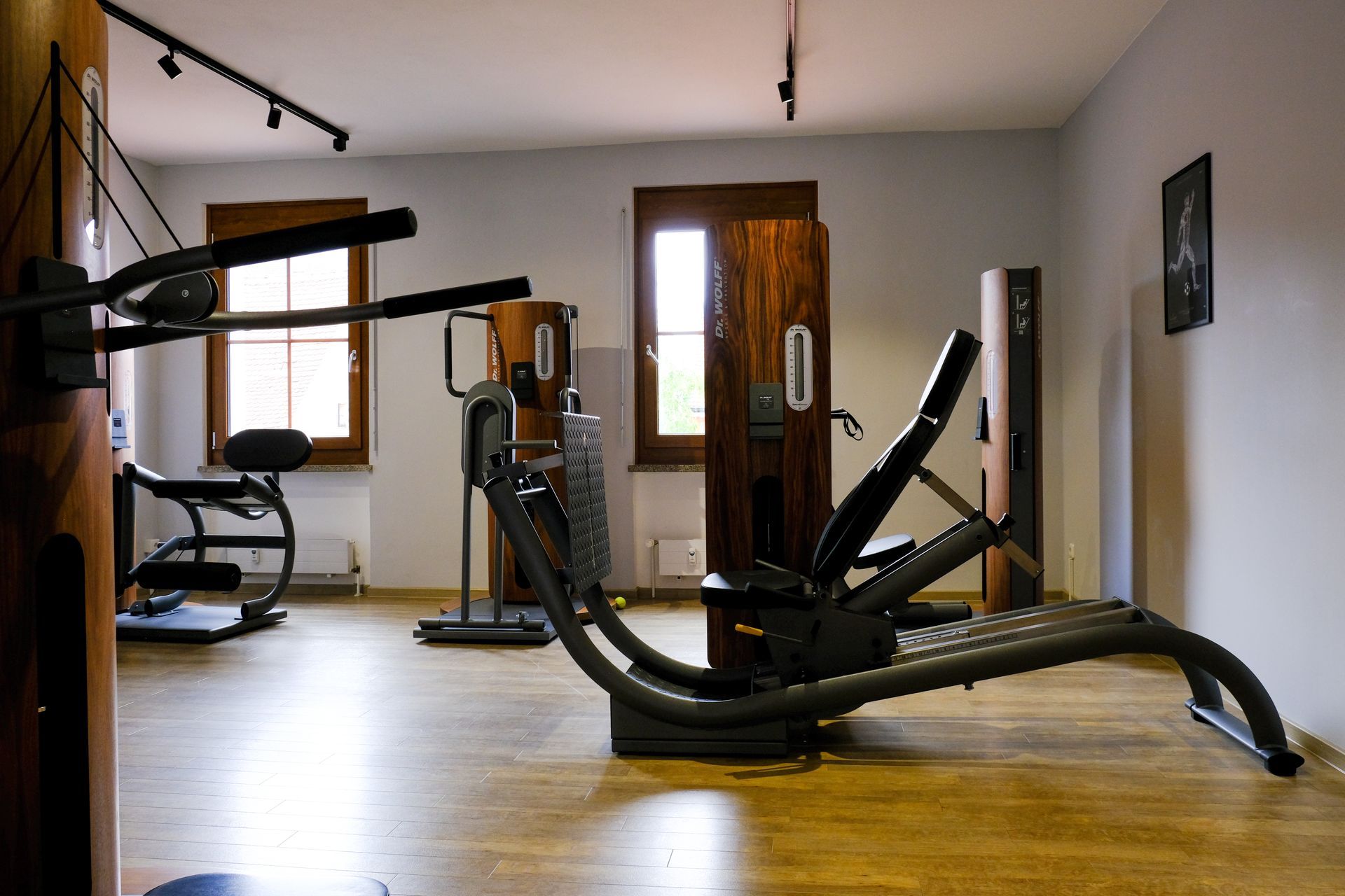 Ein Patient benutzt ein Rehabilitationsgeschirr, während ein Therapeut in einer Physiotherapie-Halle Geräte einstellt.