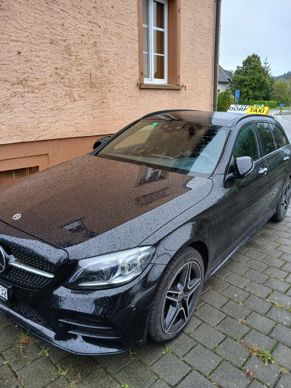 Ein schwarzes Auto parkt vor einem Gebäude.