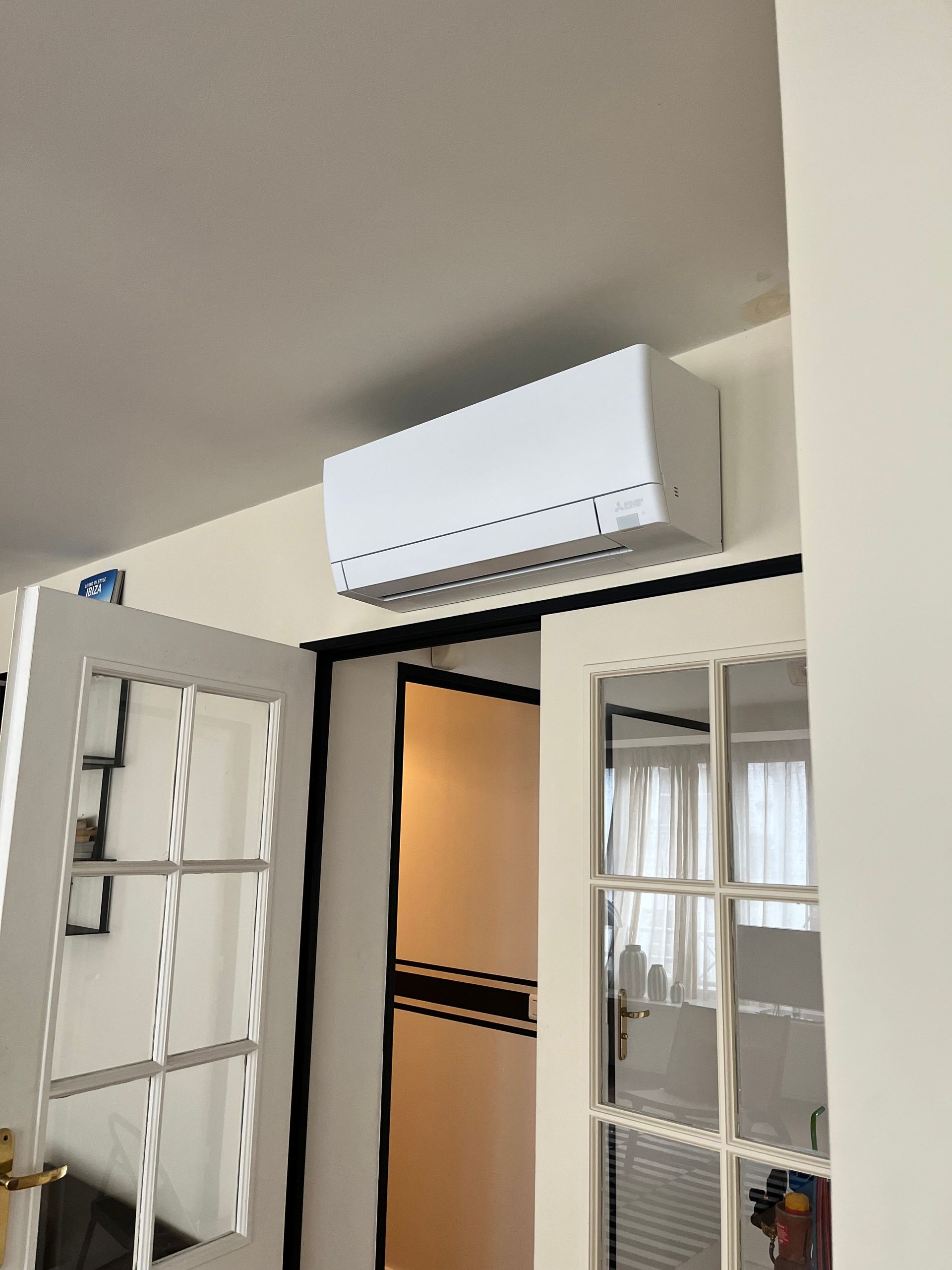 Climatiseur au-dessus d'une porte vitrée