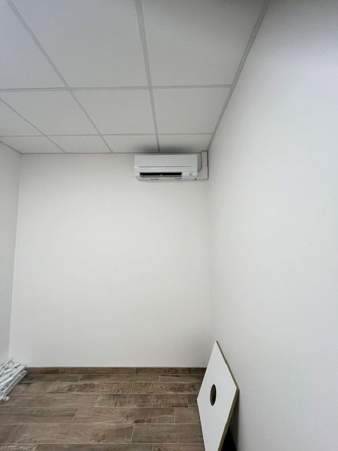 Climatisation réversible installée sur le mur, proche du plafond, dans un cabinet médical
