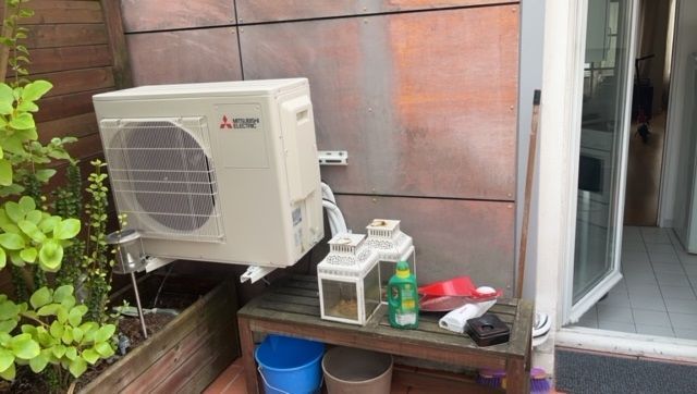 Unité extérieure d'une pompe à chaleur beige chez un particulier