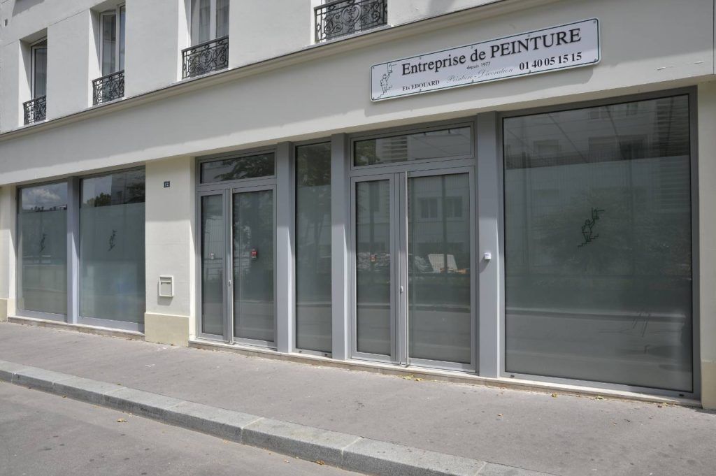 Extérieur d'une façade de magasin avec de grandes fenêtres et une enseigne indiquant « brasserie de peinture ».