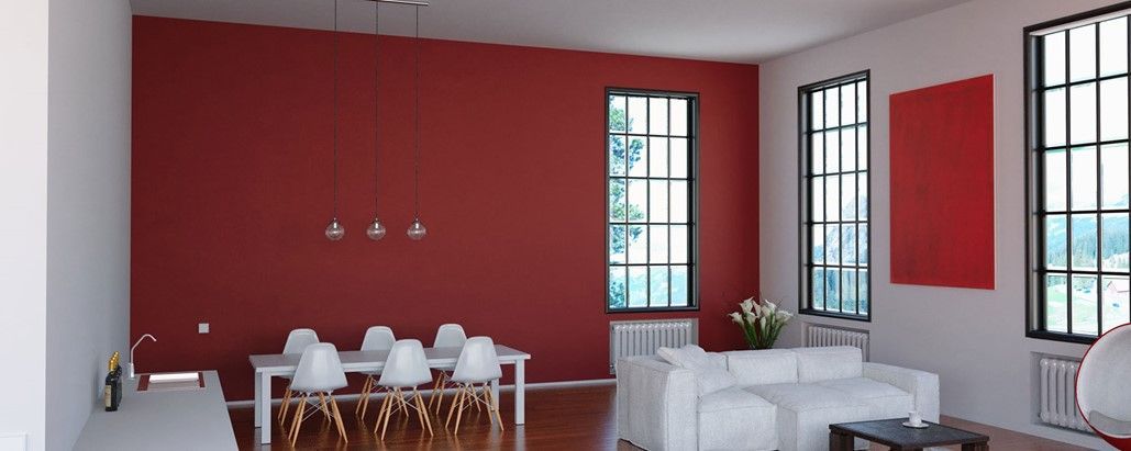 Une salle à manger moderne avec un mur d'accent rouge, des meubles blancs et une grande fenêtre.