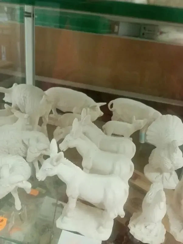 Una vitrina llena de estatuas blancas de animales.