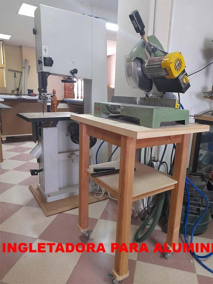 Una sierra de cinta está colocada encima de una mesa de madera.