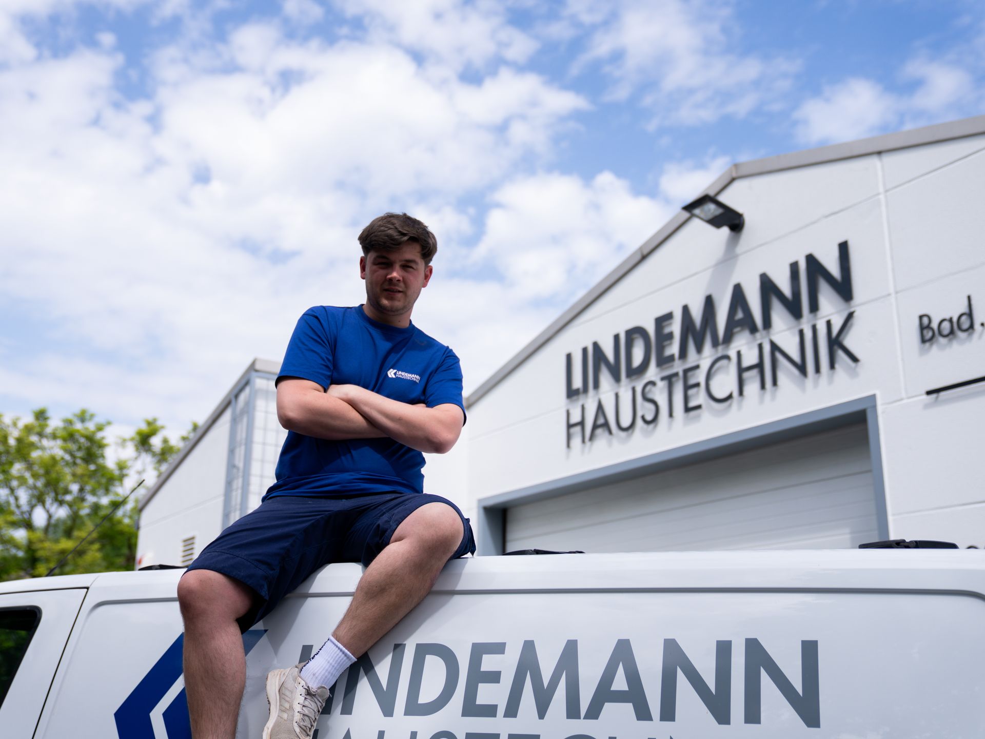 Ein Mann sitzt auf einem Lieferwagen von Lindemann Haustechnik