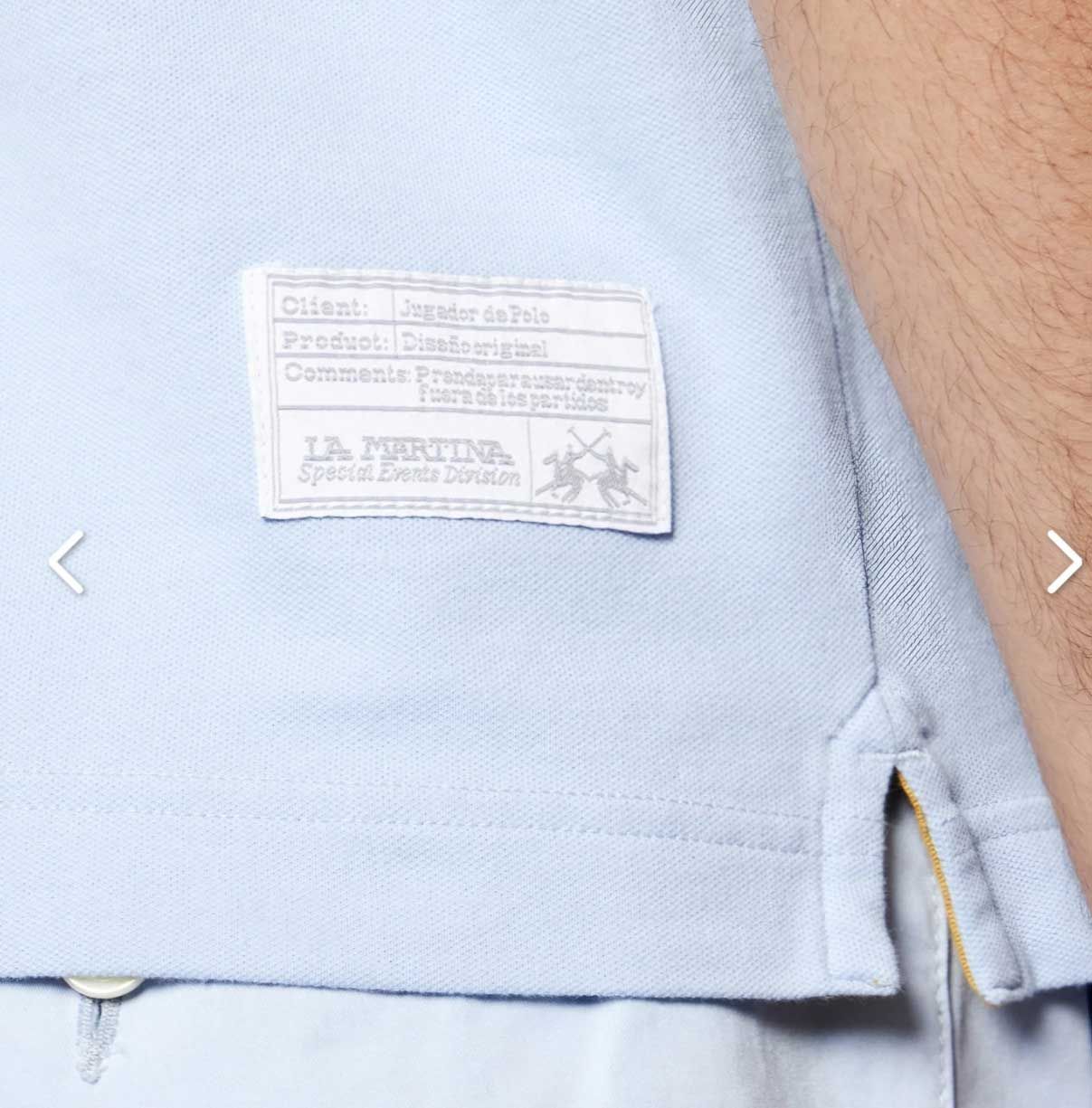 Un hombre que llevaba una camisa azul claro con una etiqueta en la espalda.