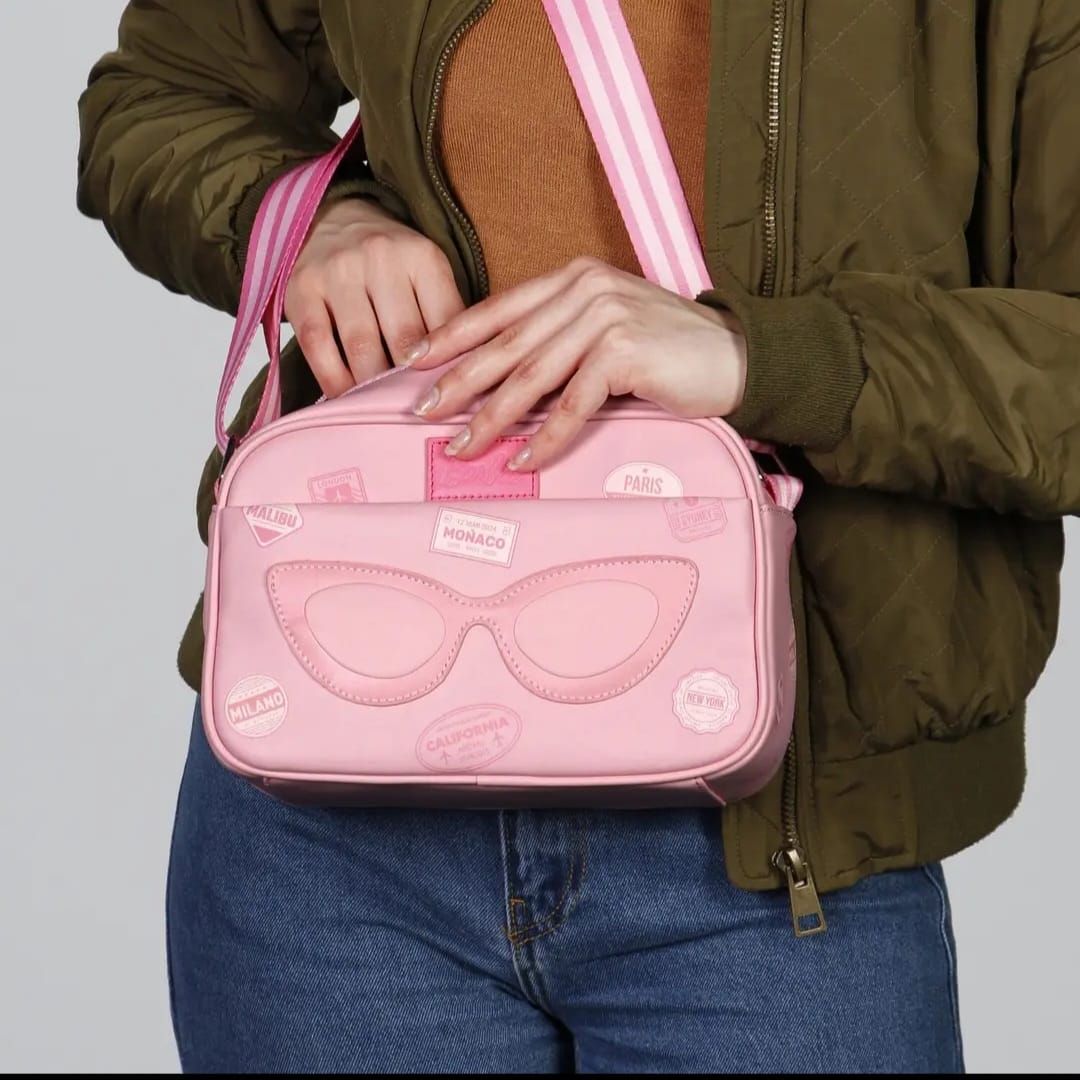 Una mujer sostiene un bolso rosa con gafas de sol.