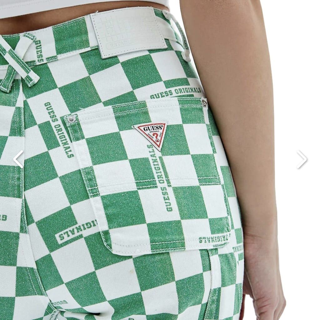 Una mujer lleva un par de pantalones a cuadros verdes y blancos.