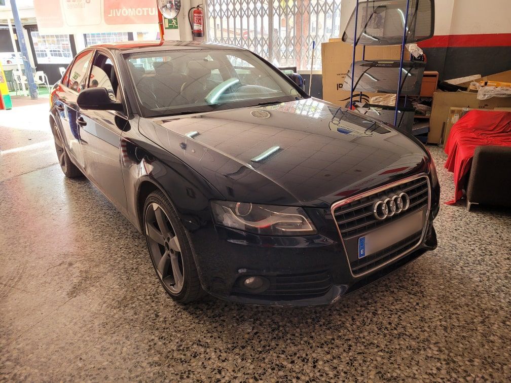 Un coche Audi negro está aparcado en un garaje.