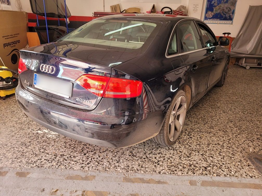 Un coche Audi negro está aparcado en un garaje.