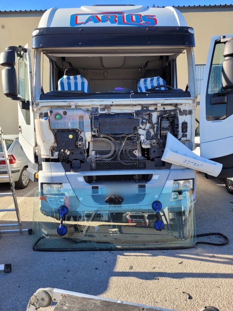 Un camión está siendo reparado en un estacionamiento.