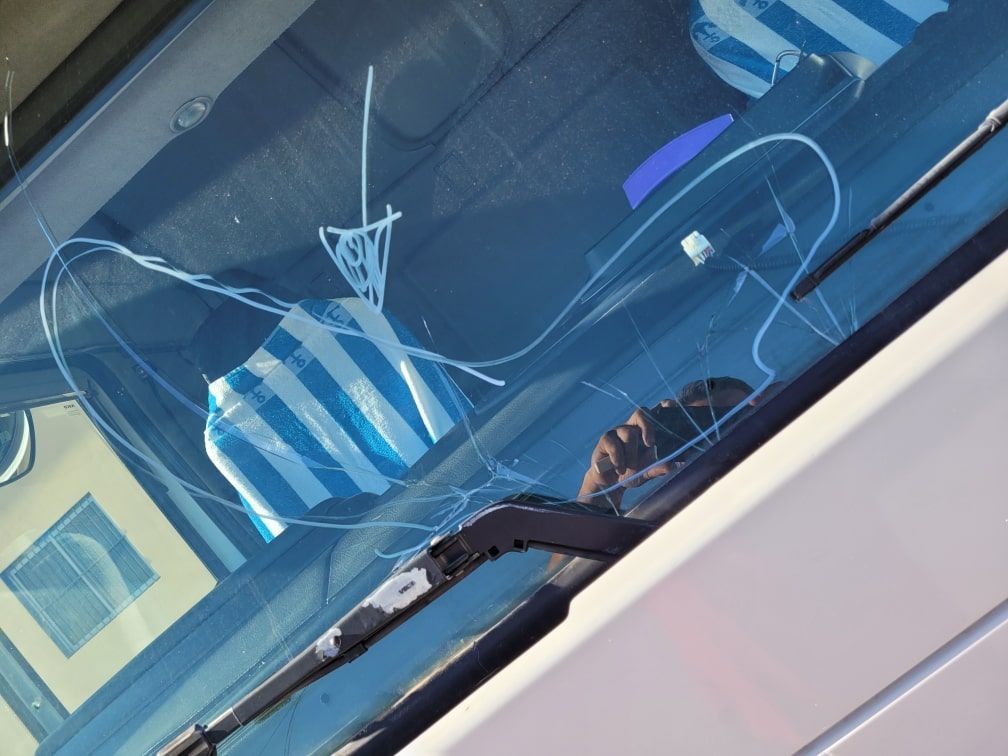 Un primer plano de un parabrisas con un limpiaparabrisas roto.