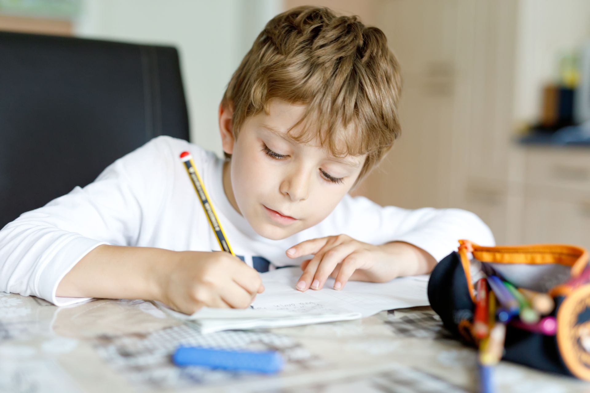 Jeune garçon qui écrit avec un crayon
