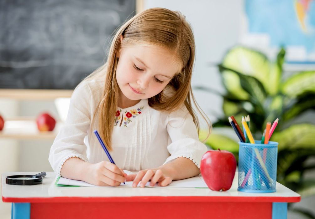 Petite fille qui écrit à l'école