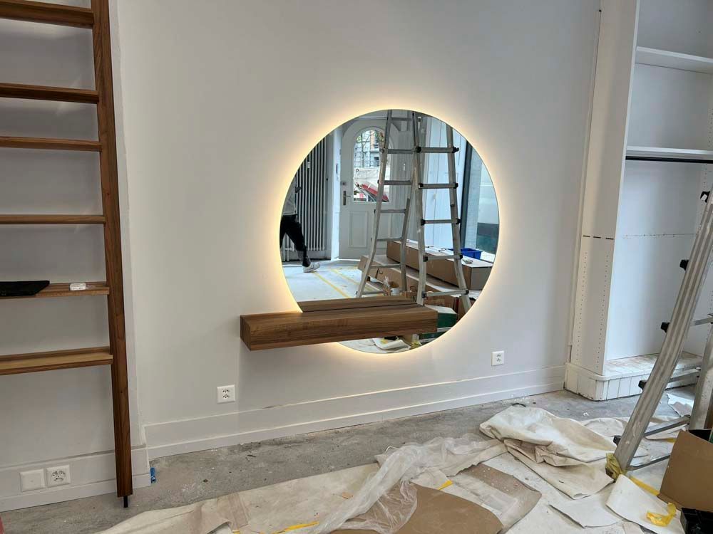 Ein großer, runder Spiegel hängt an einer Wand in einem Zimmer.