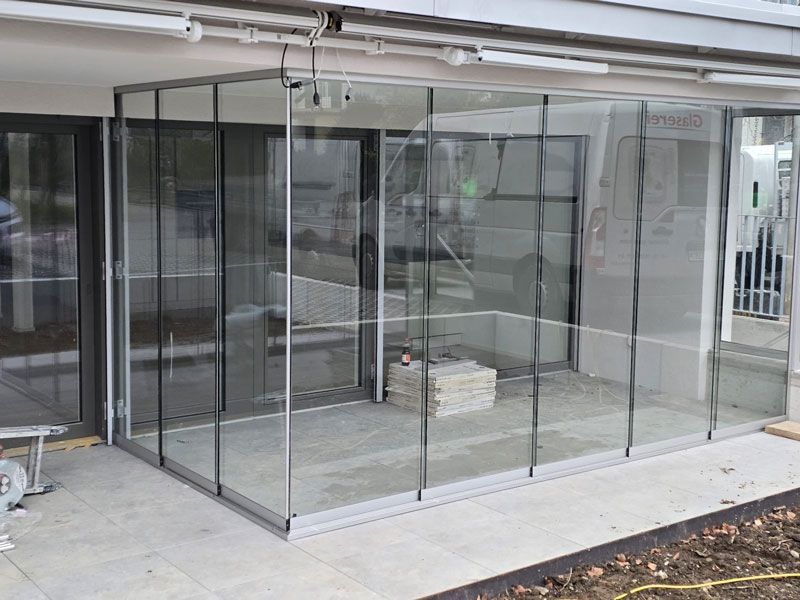 An der Seite eines Gebäudes wird eine Glaswand errichtet.