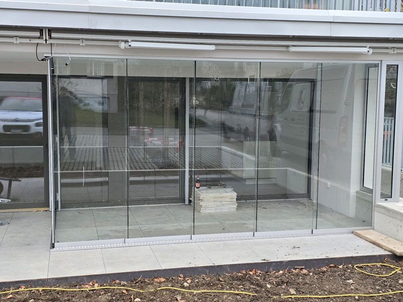 Ein Gebäude mit vielen Fenstern und Glasschiebetüren.