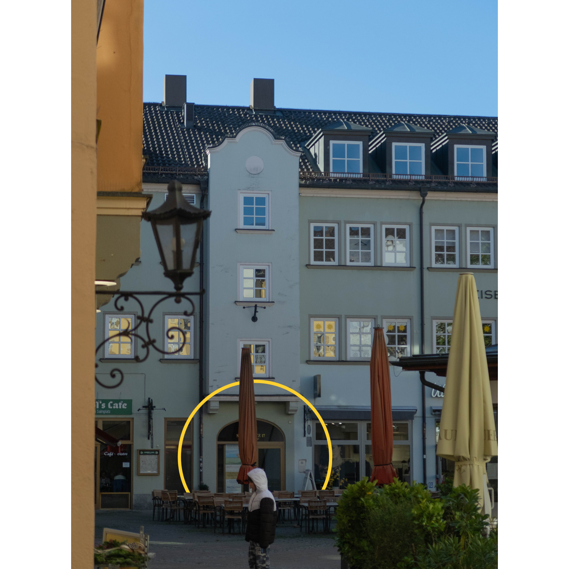 Eine Person, die mit Regenschirmen vor einem Gebäude läuft