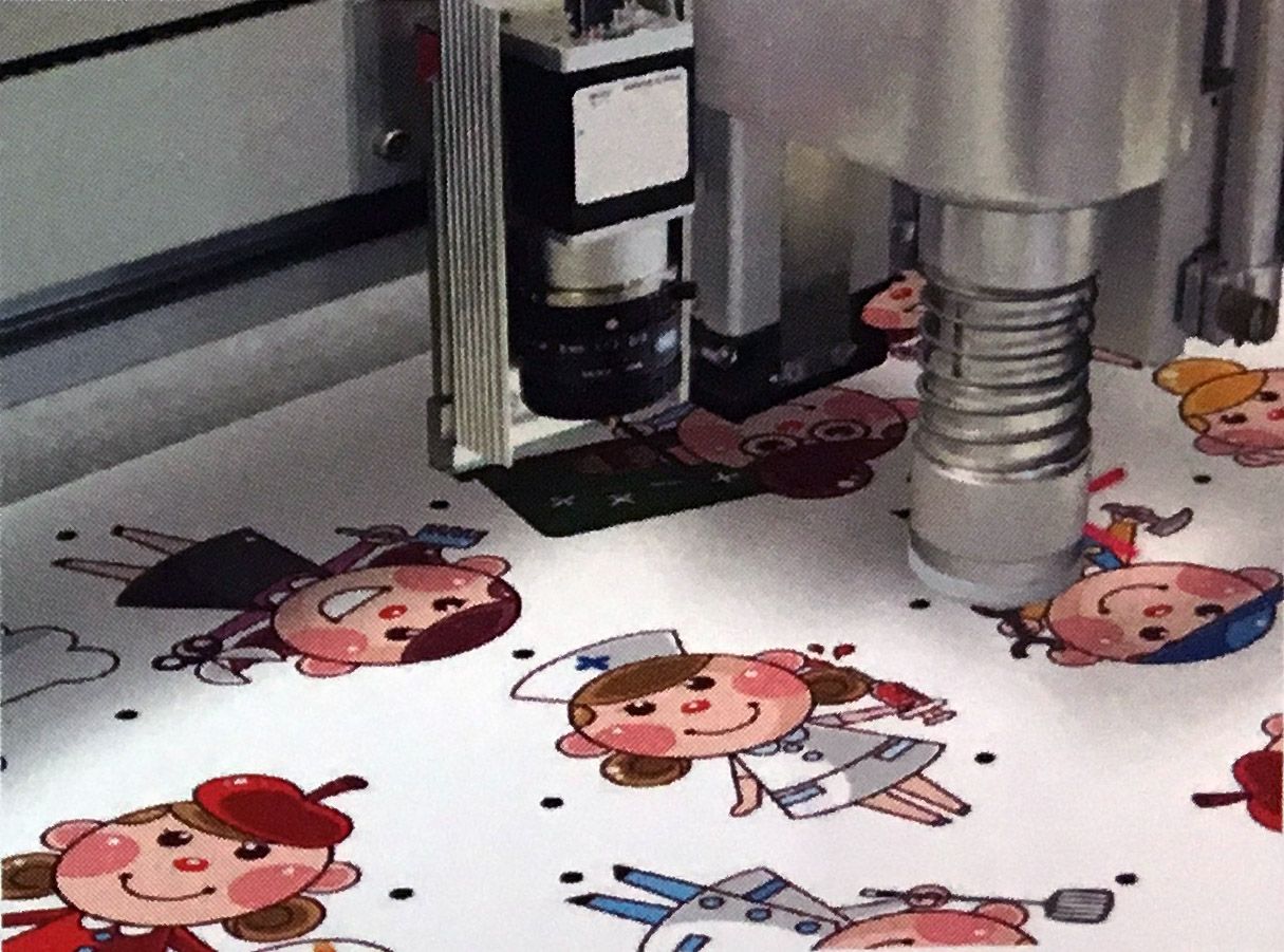 Una máquina está cortando un trozo de papel con personajes de dibujos animados.