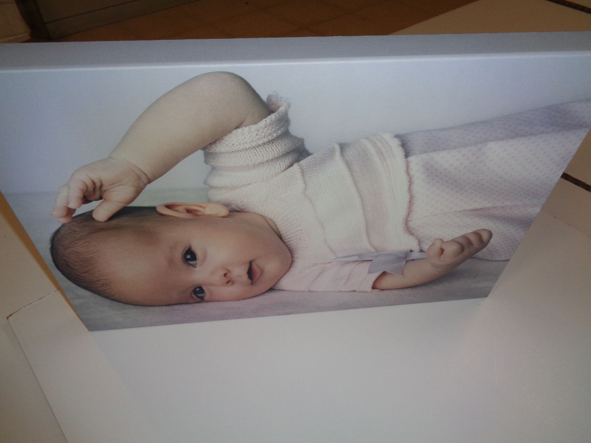 Una foto de un bebé acostado sobre una manta.