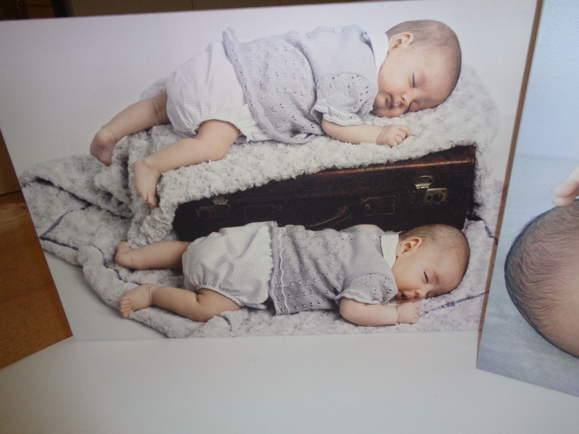 Dos bebés acostados uno encima del otro sobre una manta