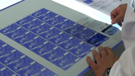 Una persona con una bata blanca está mirando una hoja de papel.