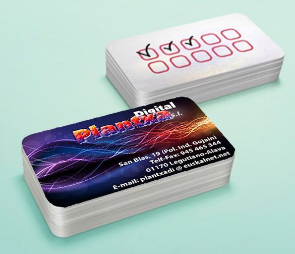 Dos tarjetas de presentación están apiladas una encima de otra sobre una superficie verde.