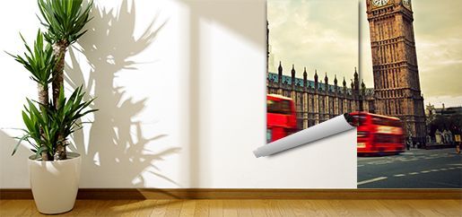 Una habitación con una planta y una imagen de un autobús rojo en la pared.