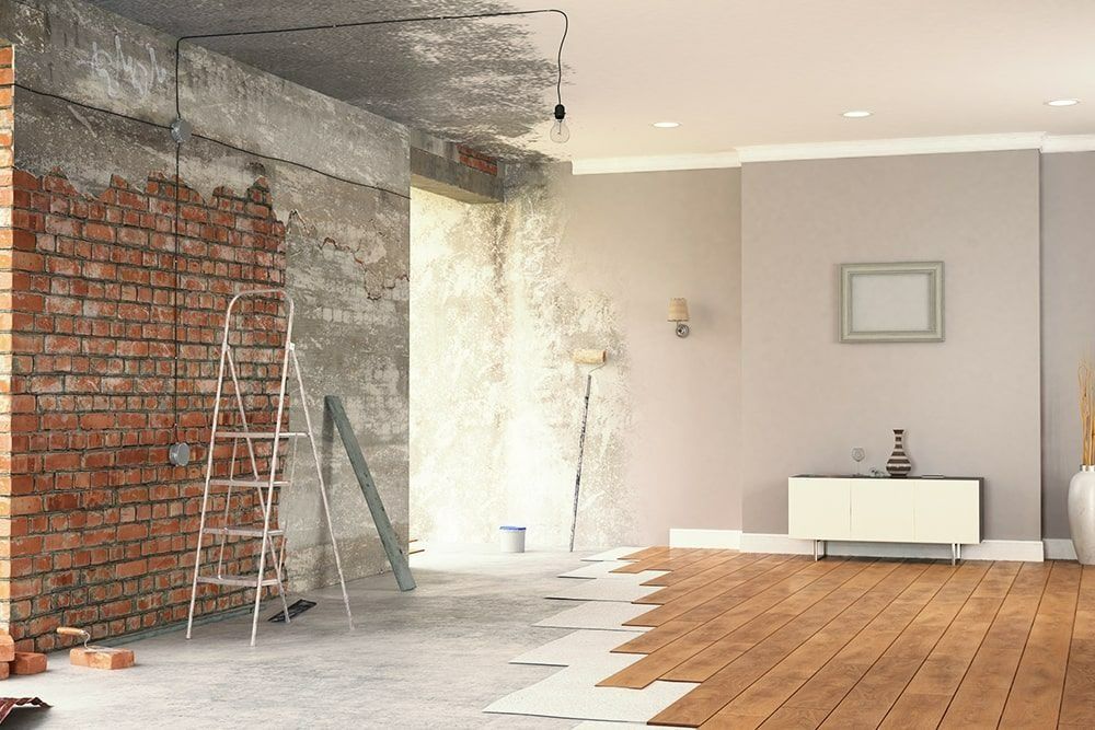 Salon partiellement rénové avec mur de briques apparentes, échelle et parquet en cours de rénovation