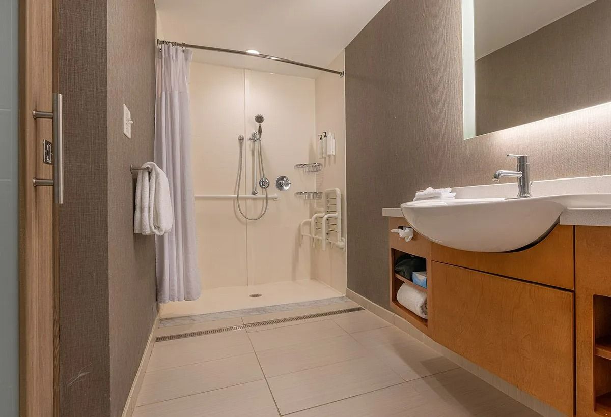 Salle de bains moderne avec douche à l'italienne, meuble vasque et sol carrelé beige