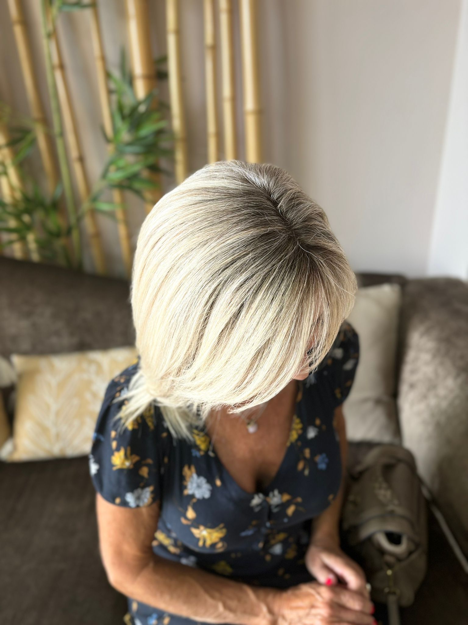 Una mujer con cabello rubio está sentada en un sofá.