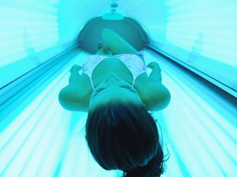 Una mujer en bikini está tumbada en una cama solar.