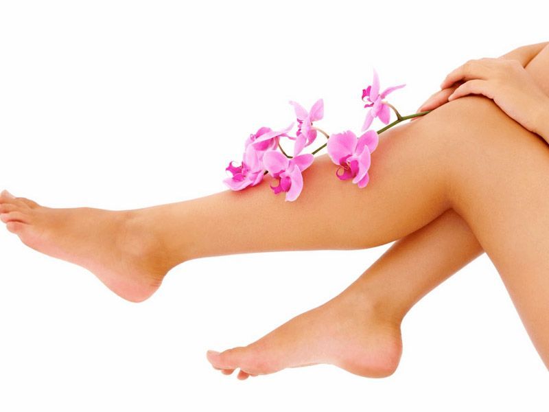 Las piernas de una mujer con flores rosas en ellas.