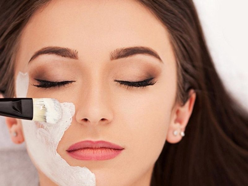 Una mujer está recibiendo un tratamiento facial con un cepillo en su cara.