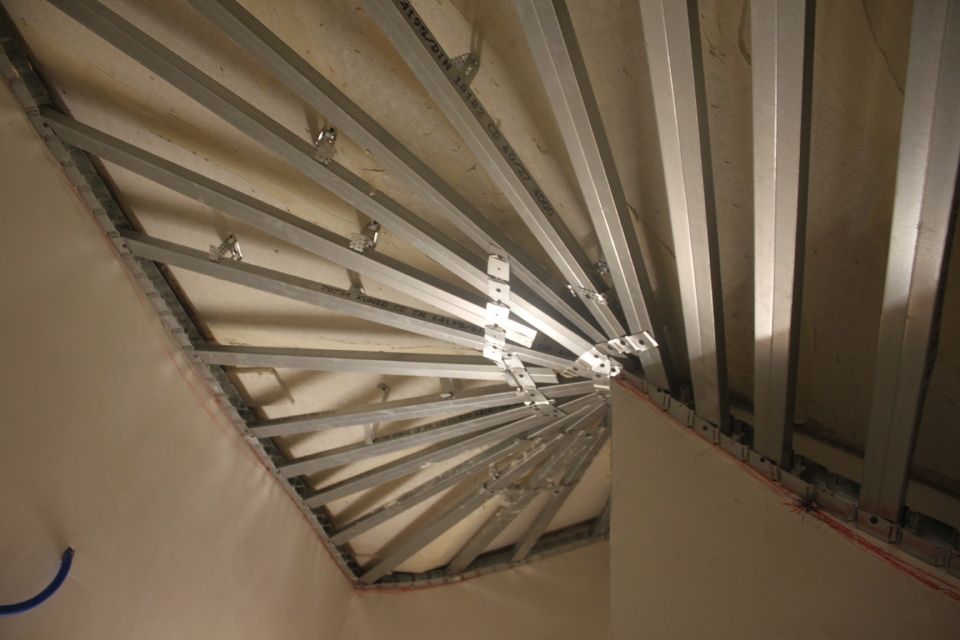 Metallene Deckenkonstruktion in einem Raum, bei der die Träger von einem zentralen Punkt ausgehen.