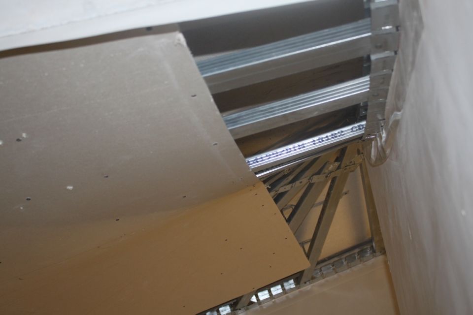 An der Decke wurden teilweise Gipskartonplatten angebracht, wodurch das Metallgerüst sichtbar wird.